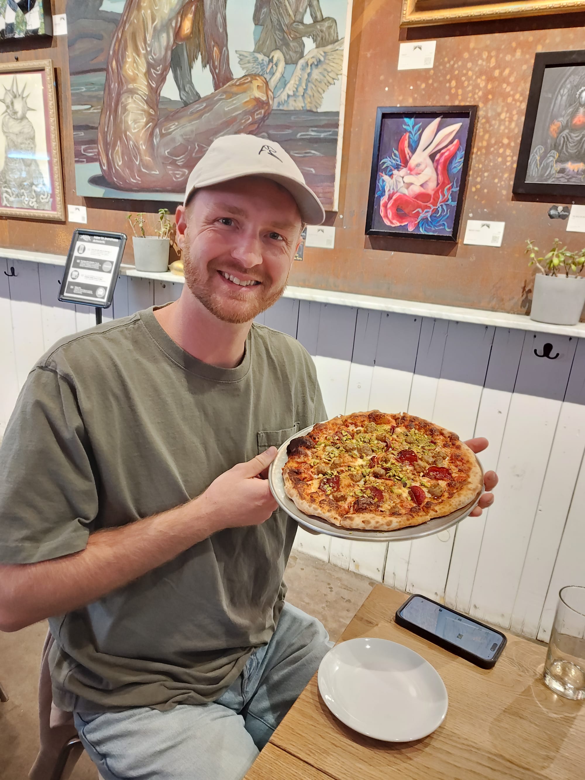 man holding a spicy, pepperoni pizza