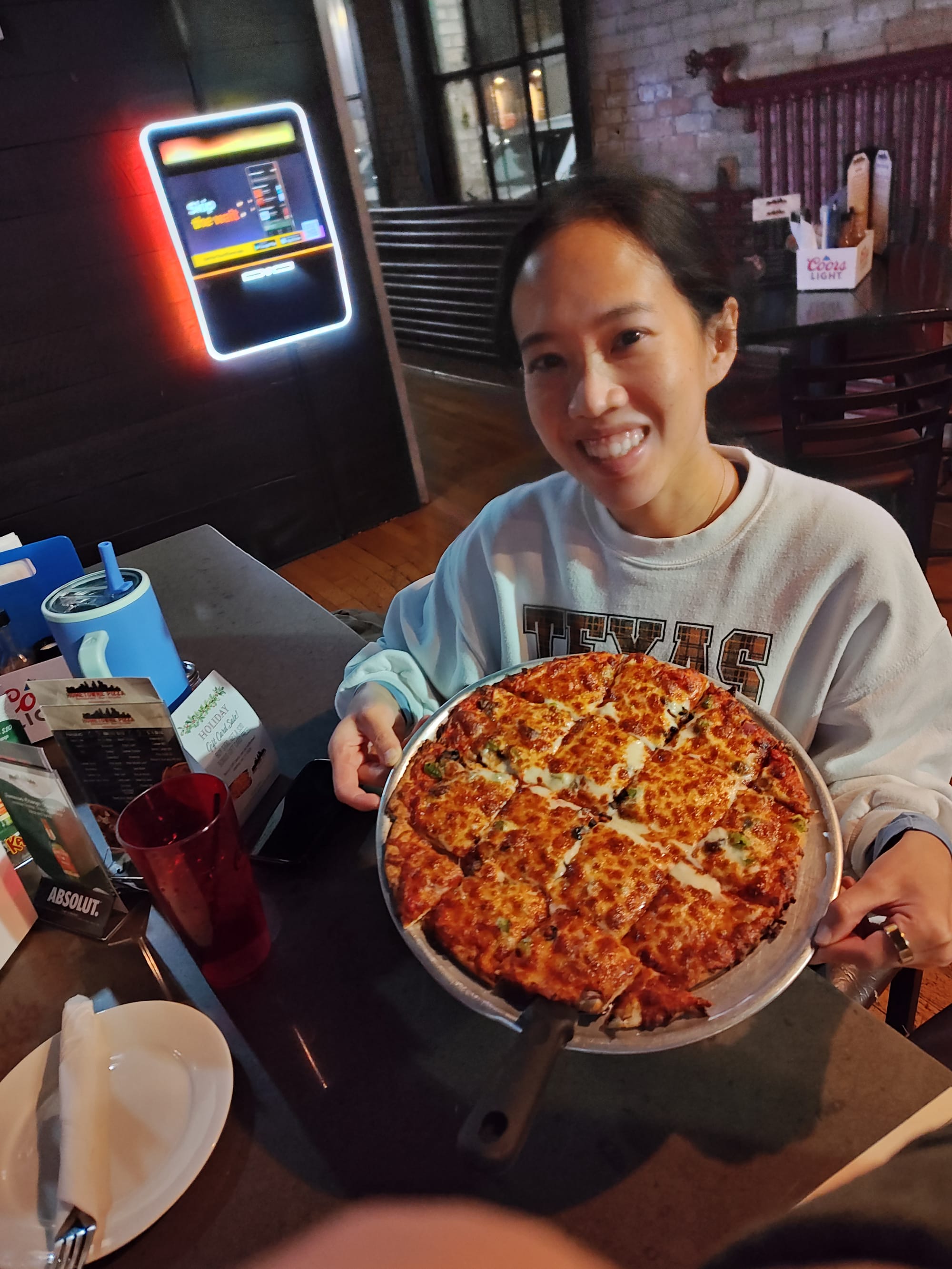 woman holding a veggie pizza