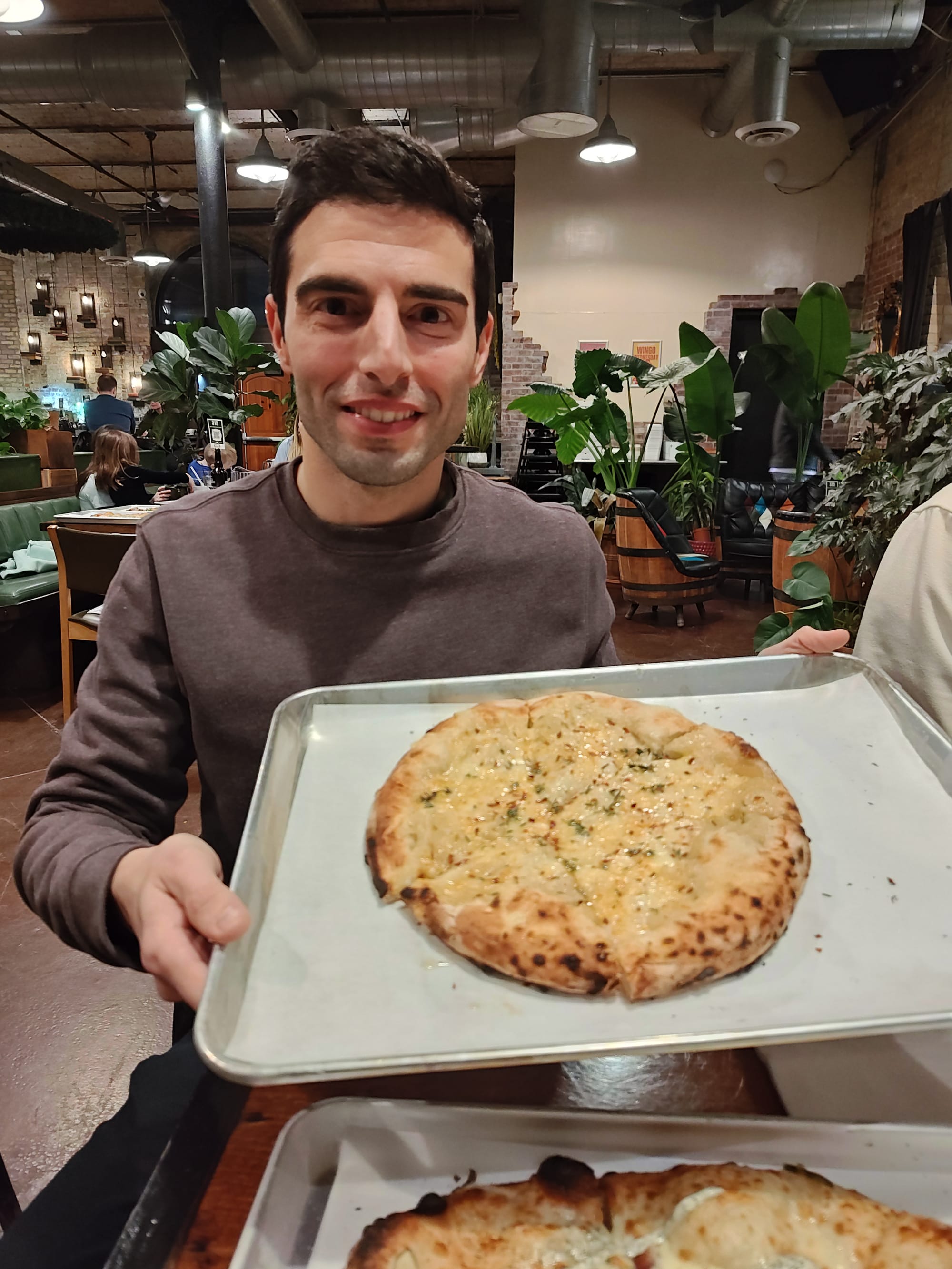 man holding an onion pizza